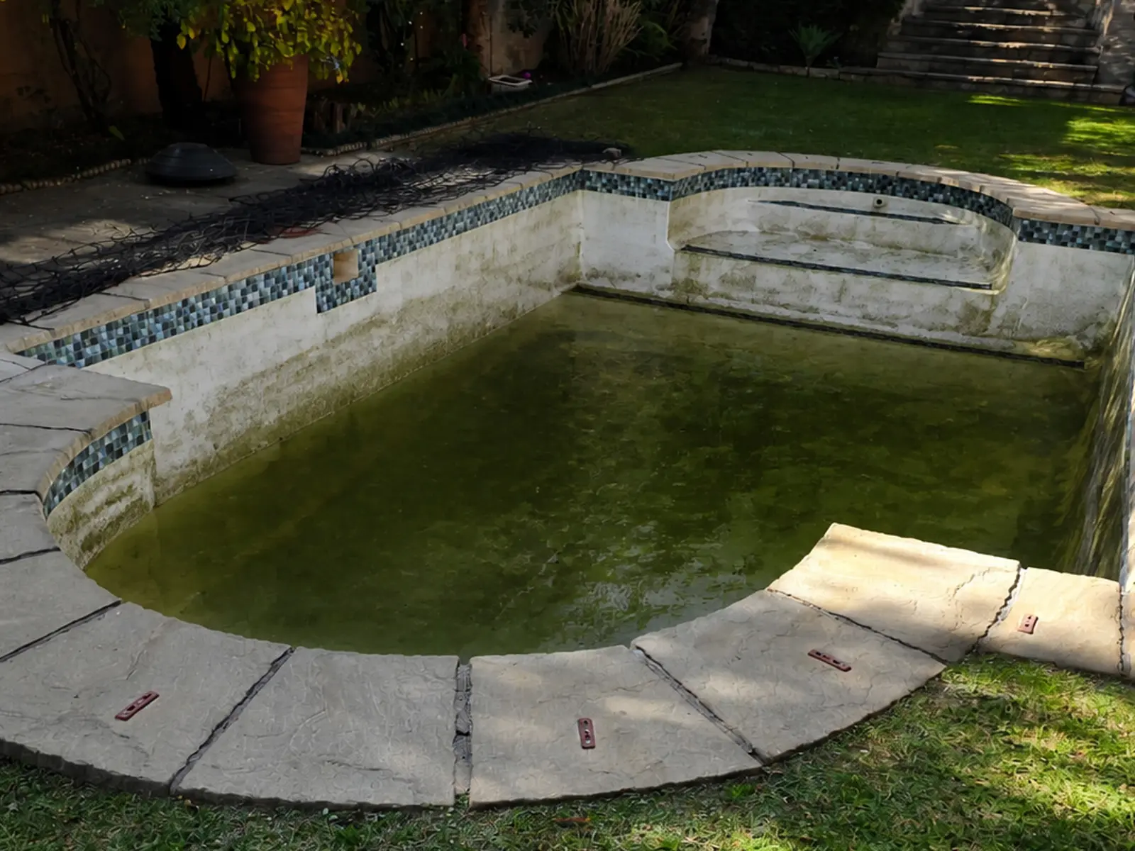 Damaged fibreglass swimming pool before professional repair