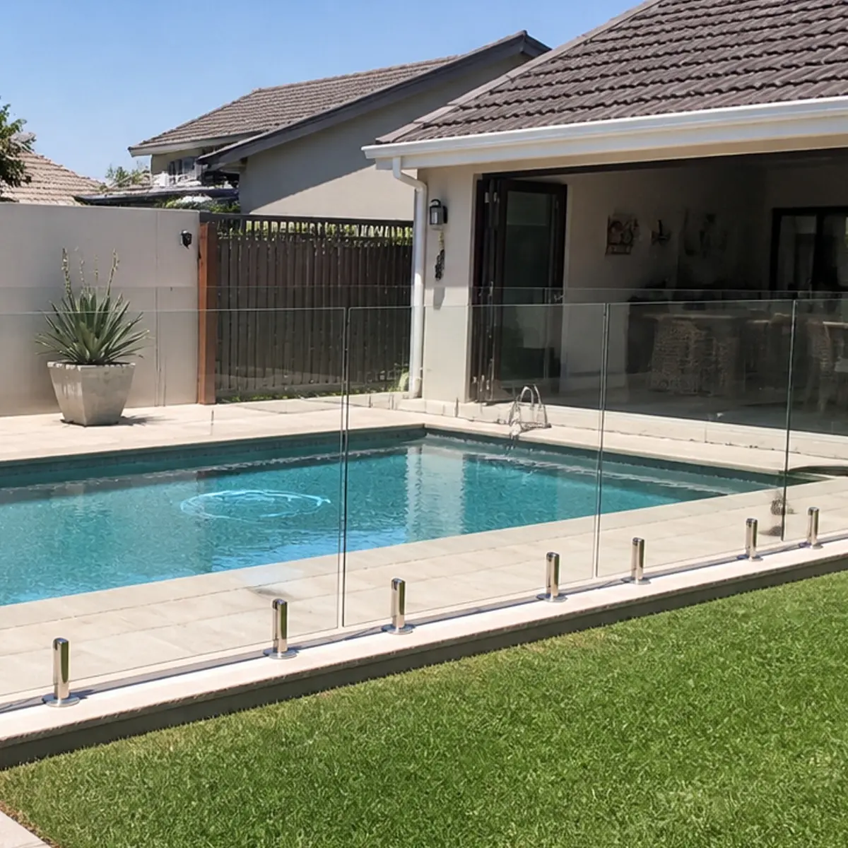 Glass pool fencing around a modern residential swimming pool