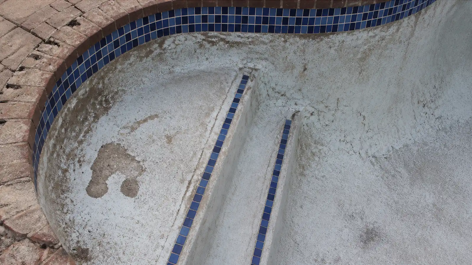 Damaged swimming pool steps before renovation