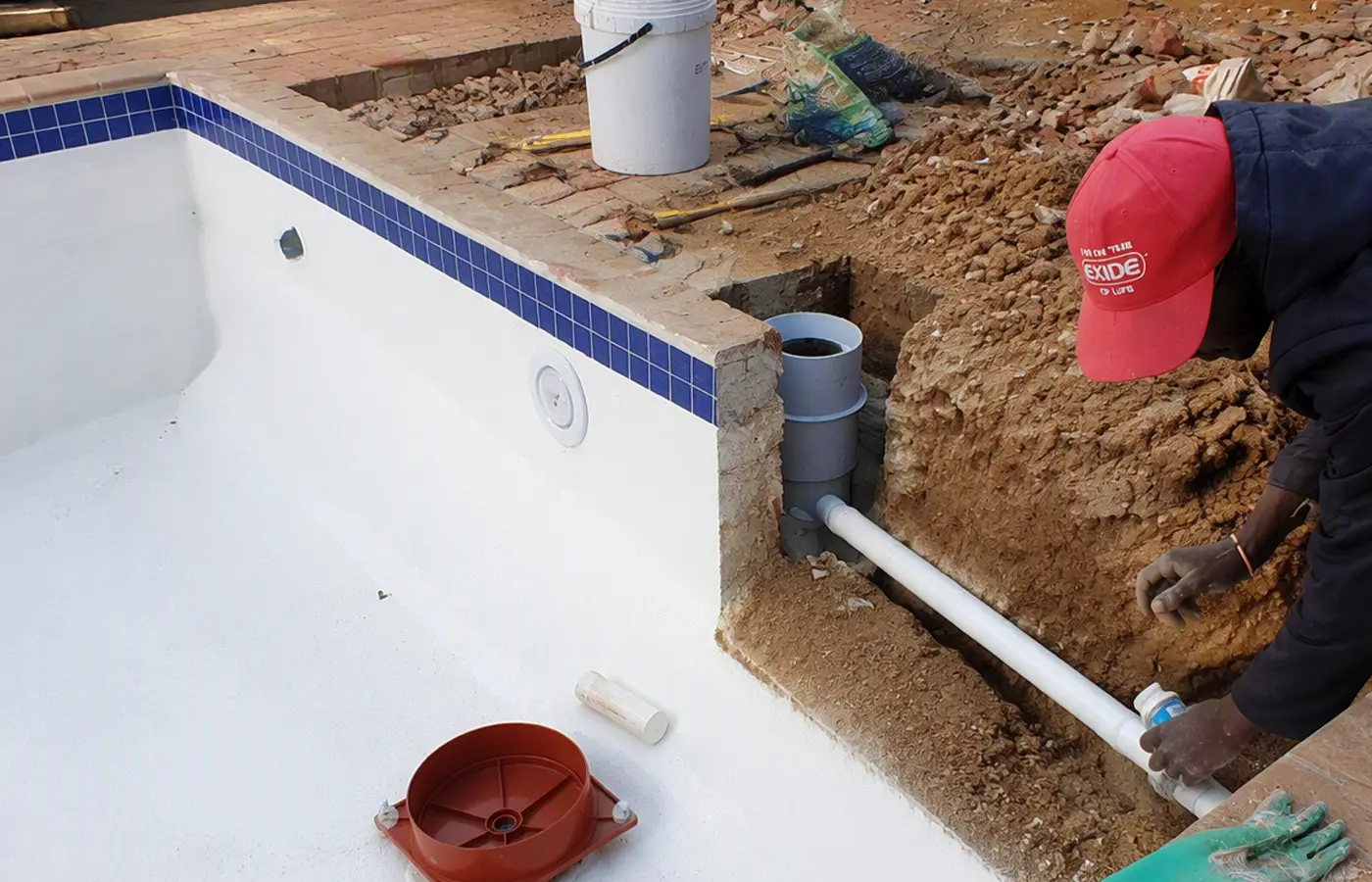 Swimming pool plumbing exposed during pool leak repair